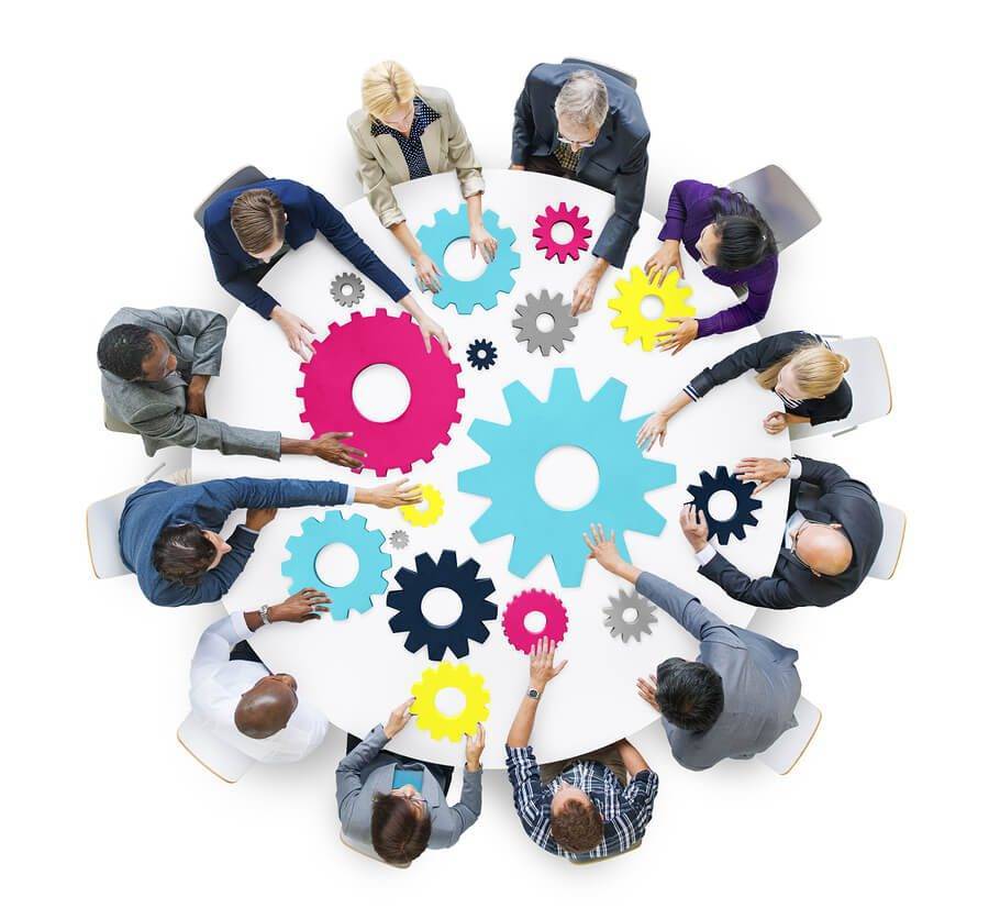 Business meeting with workers holding cogs