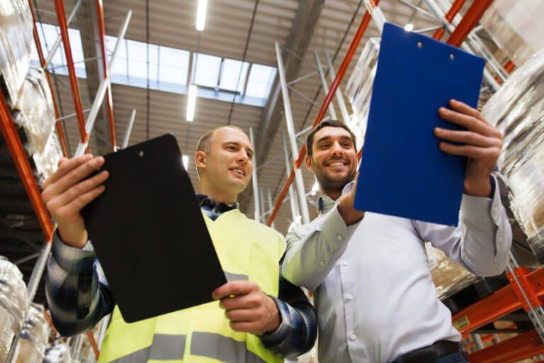 Two business men talking over clipboards while smiling optimize eCommerce