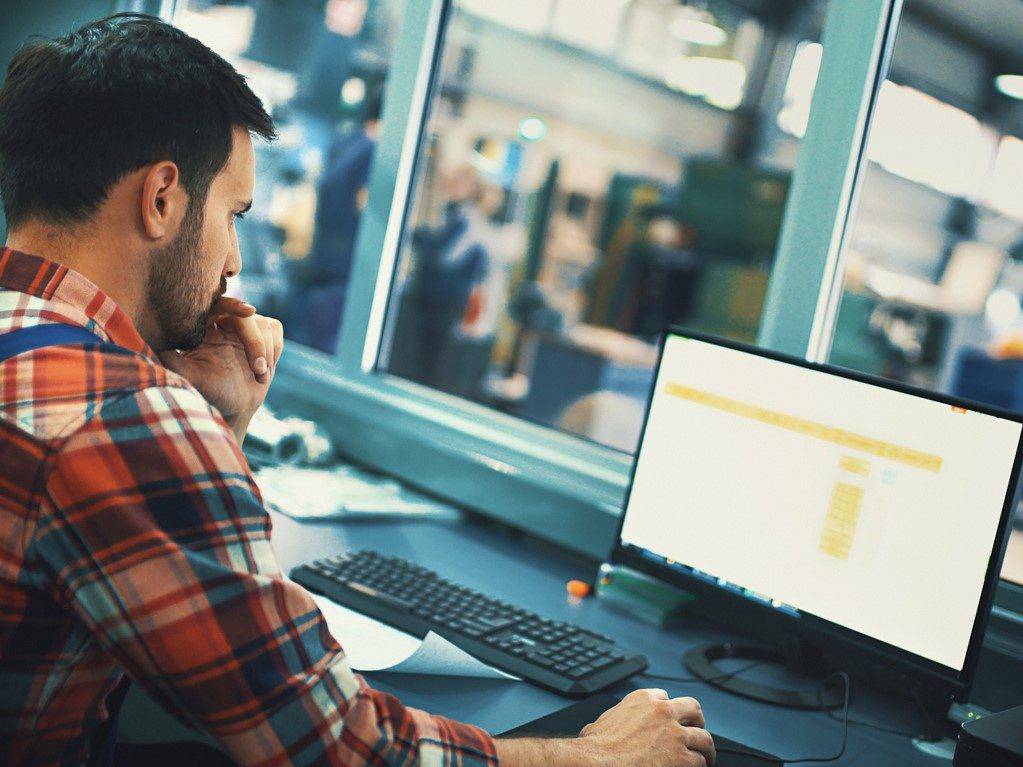 Man analyzing data on computer screen Q&A manufacturing execution systems